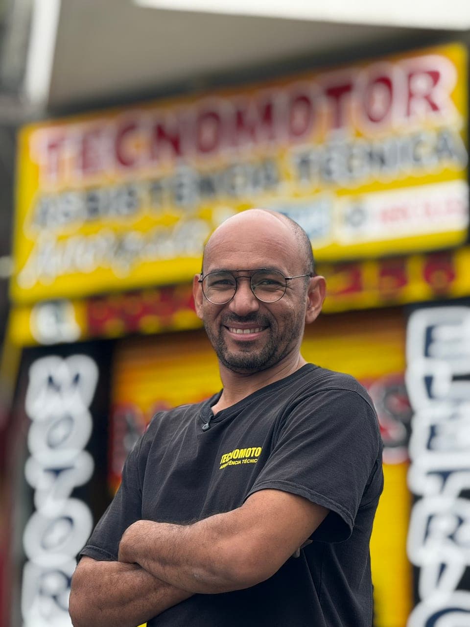 César Cruz, fundador da Tecnomotor, sorrindo em frente à loja em Campinas